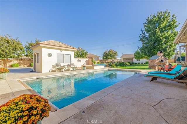 2534 Desert Rose Dr, Lancaster, CA 93536 - view of swimming pool featuring an exterior structure, a patio, an outbuilding, and a fireplace