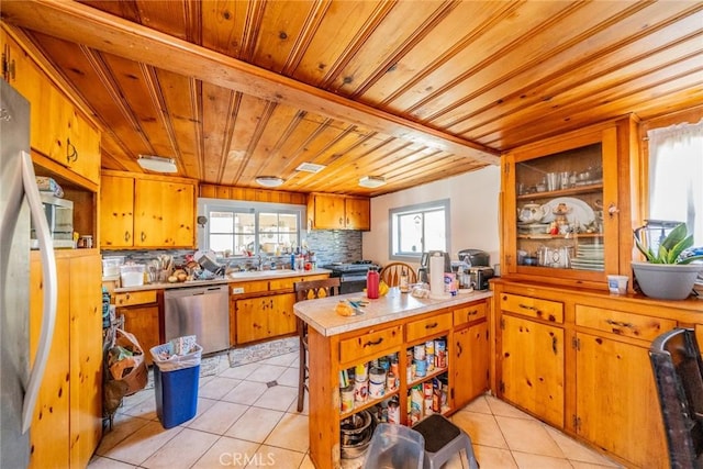 9964 Cedar Ave, Bloomington, CA 92316 - kitchen with dishwasher, wood ceiling, light countertops, light tile patterned floors, and brown cabinetry