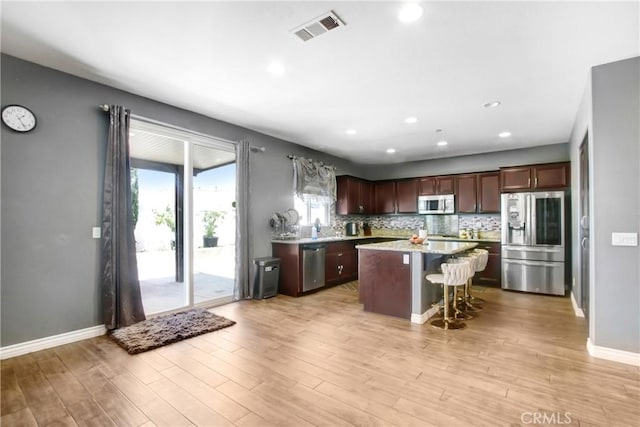 26810 Sugarite Canyon Dr, Moreno Valley, CA 92555 - kitchen featuring appliances with stainless steel finishes, a center island, a breakfast bar, light wood-style flooring, and recessed lighting