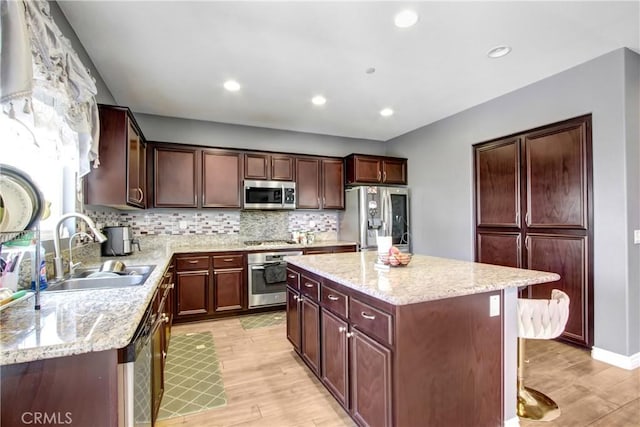 26810 Sugarite Canyon Dr, Moreno Valley, CA 92555 - kitchen with stainless steel appliances, light wood-style floors, a kitchen island, tasteful backsplash, and recessed lighting