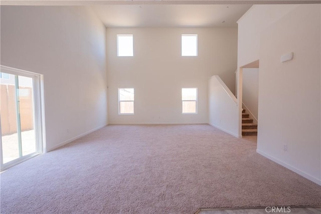 363 Arpent Ct, Merced, CA 95341 - unfurnished living room with a towering ceiling, carpet, and stairway