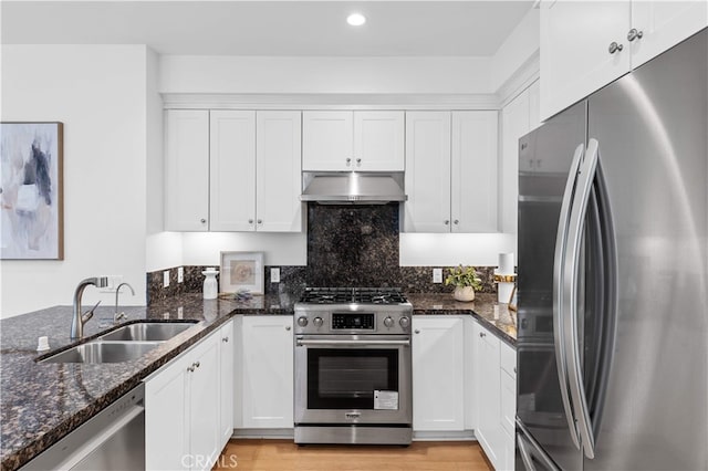 186 Bishop Lndg, Irvine, CA 92620 - kitchen with appliances with stainless steel finishes, under cabinet range hood, white cabinetry, dark stone counters, and recessed lighting