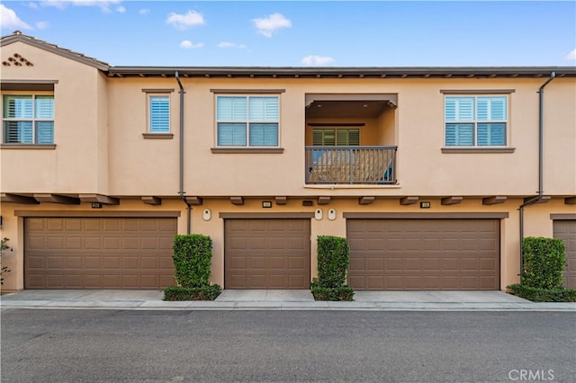186 Bishop Lndg, Irvine, CA 92620 - view of property with stucco siding, an attached garage, and a balcony