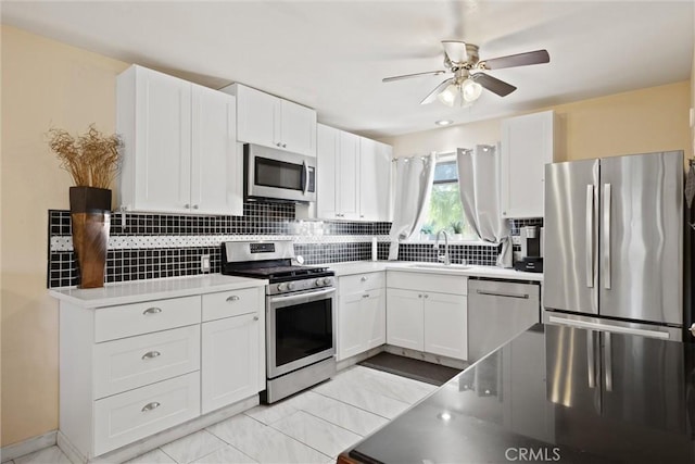 1094 Manzanita Ave, Chico, CA 95926 - kitchen with stainless steel appliances, tasteful backsplash, white cabinetry, and a ceiling fan
