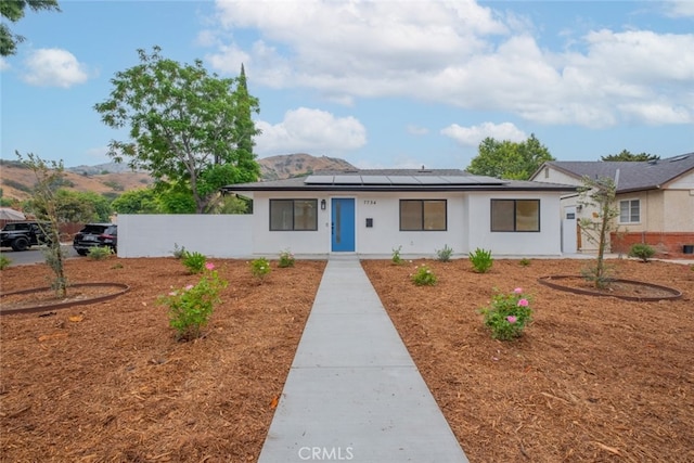 7734 N Glenoaks Blvd, Burbank, CA 91504 - view of front of home featuring solar panels, a mountain view, and stucco siding