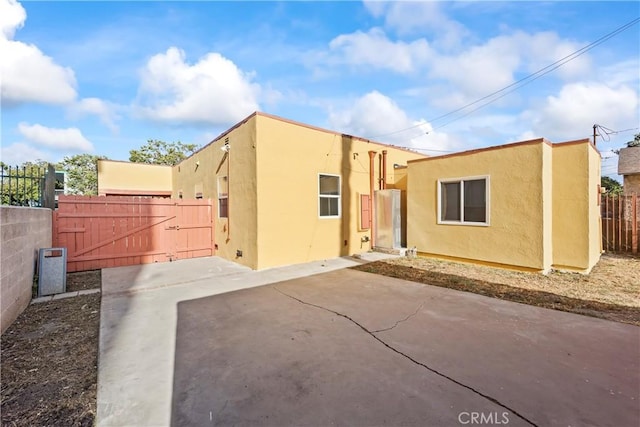 8727 S Harvard Blvd, Los Angeles, CA 90047 - back of house featuring a gate, stucco siding, and a patio