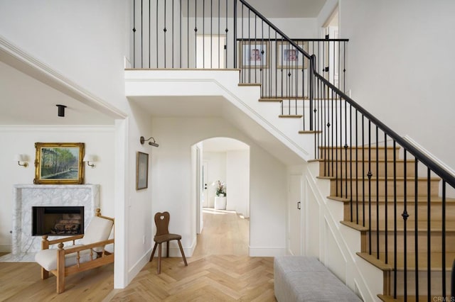 17274 Calle Mayor, Rancho Santa Fe, CA 92067 - stairway with arched walkways, a high ceiling, and a premium fireplace