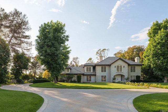 17274 Calle Mayor, Rancho Santa Fe, CA 92067 - view of front of house with curved driveway, a front lawn, a chimney, and stucco siding
