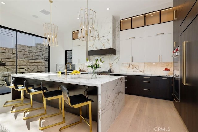 19031 Fowler Ave, North Tustin, CA 92705 - kitchen with a breakfast bar area, light wood finished floors, decorative backsplash, and recessed lighting