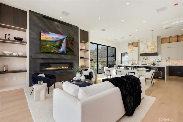 19031 Fowler Ave, North Tustin, CA 92705 - living area with light wood-style flooring, a large fireplace, recessed lighting, and built in features