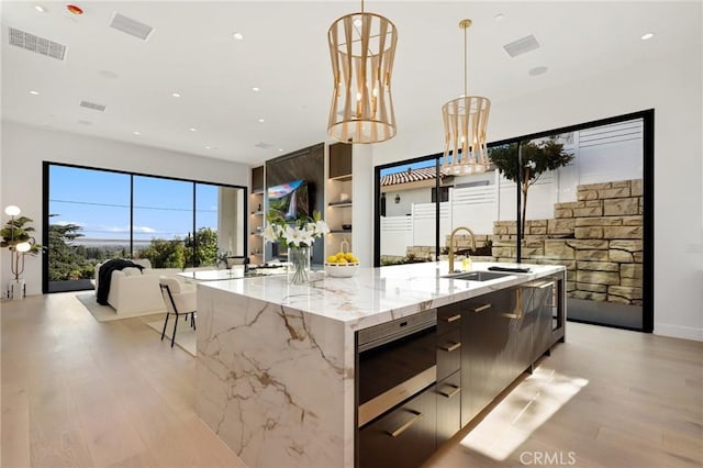 19031 Fowler Ave, North Tustin, CA 92705 - kitchen featuring modern cabinets, stainless steel microwave, a large island, light wood-type flooring, and recessed lighting
