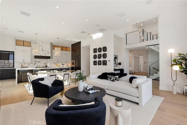 19031 Fowler Ave, North Tustin, CA 92705 - living room with light wood-style floors, stairway, recessed lighting, a chandelier, and a towering ceiling