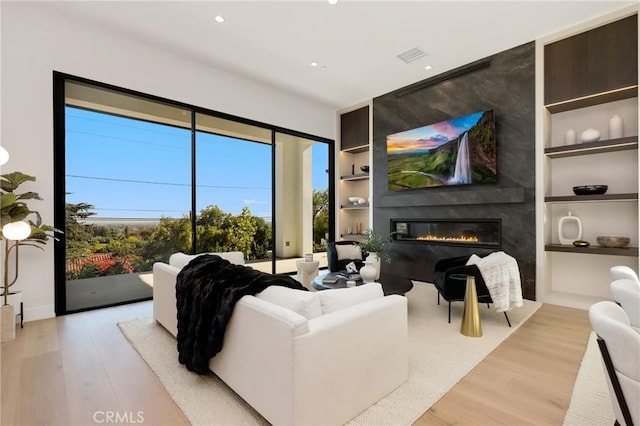 19031 Fowler Ave, North Tustin, CA 92705 - living room featuring built in features, light wood-type flooring, a fireplace, and recessed lighting