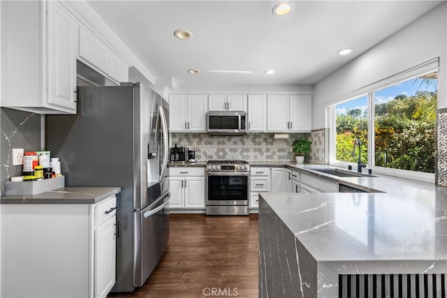 27814 Caraway Ln, Saugus, CA 91350 - kitchen with appliances with stainless steel finishes, dark wood-style flooring, white cabinetry, backsplash, and recessed lighting