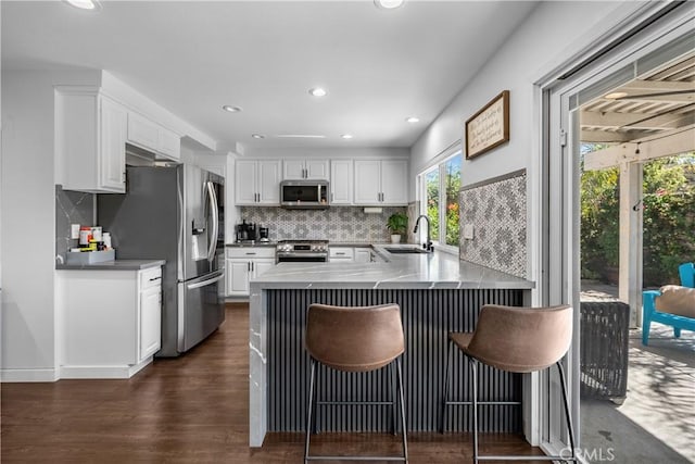 27814 Caraway Ln, Saugus, CA 91350 - kitchen featuring stainless steel appliances, a peninsula, white cabinets, backsplash, and recessed lighting