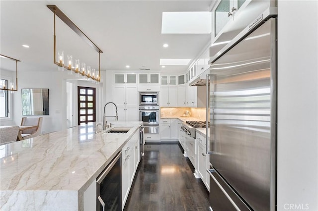 444 Morning Canyon Rd, Corona Del Mar, CA 92625 - kitchen featuring built in appliances, a spacious island, white cabinets, light stone countertops, and dark wood-type flooring