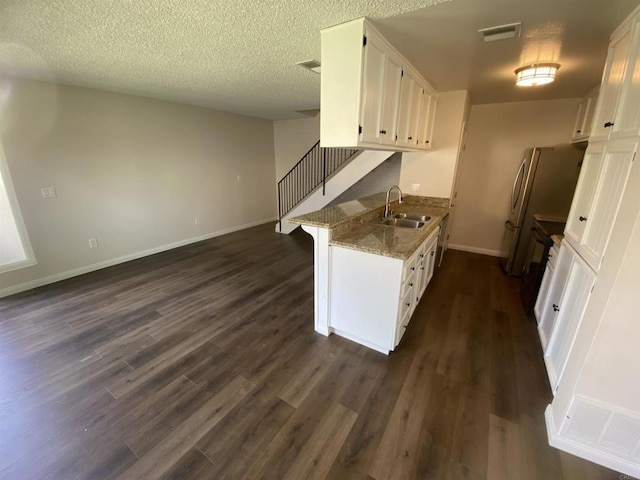 9847 Mission Vega Rd Unit 3, Santee, CA 92071 - kitchen with white cabinets, dark wood-type flooring, light stone countertops, freestanding refrigerator, and a textured ceiling