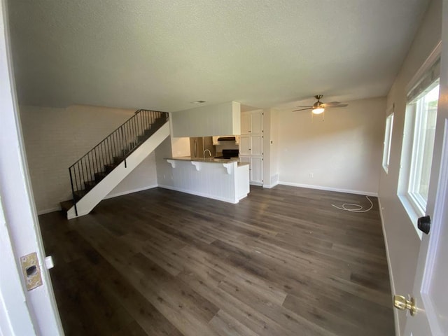 9847 Mission Vega Rd Unit 3, Santee, CA 92071 - unfurnished living room featuring dark wood-style flooring, a ceiling fan, stairs, and a textured ceiling