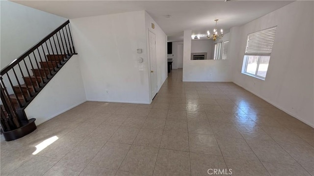 1679 Stoneside Dr, Hemet, CA 92545 - unfurnished living room featuring a chandelier, stairs, and tile patterned flooring
