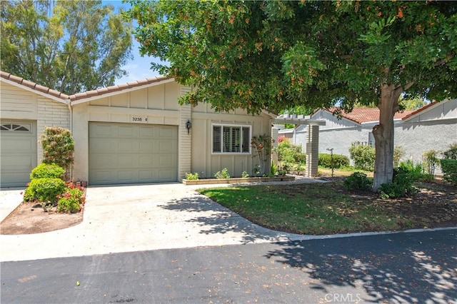 3238 San Amadeo Unit C, Laguna Woods, CA 92637 - townhome / multi-family property with board and batten siding, driveway, and an attached garage
