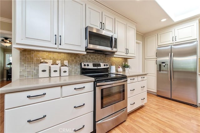3238 San Amadeo Unit C, Laguna Woods, CA 92637 - kitchen with appliances with stainless steel finishes, tasteful backsplash, light countertops, light wood-type flooring, and recessed lighting