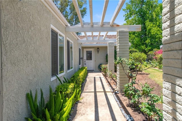 3238 San Amadeo Unit C, Laguna Woods, CA 92637 - view of exterior entry featuring stucco siding and a pergola