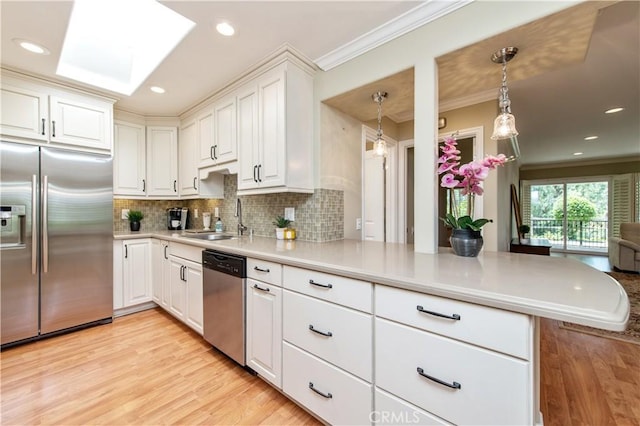 3238 San Amadeo Unit C, Laguna Woods, CA 92637 - kitchen with stainless steel appliances, ornamental molding, light wood-type flooring, tasteful backsplash, and white cabinetry