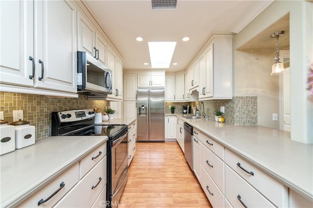 3238 San Amadeo Unit C, Laguna Woods, CA 92637 - kitchen with stainless steel appliances, tasteful backsplash, light countertops, white cabinetry, and recessed lighting
