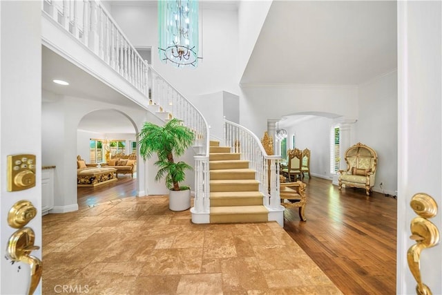29212 Dean St, Laguna Niguel, CA 92677 - entrance foyer featuring arched walkways, a chandelier, stairs, a towering ceiling, and ornate columns