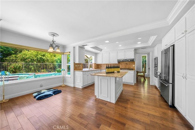 29212 Dean St, Laguna Niguel, CA 92677 - kitchen with appliances with stainless steel finishes, under cabinet range hood, a raised ceiling, white cabinets, and ornamental molding