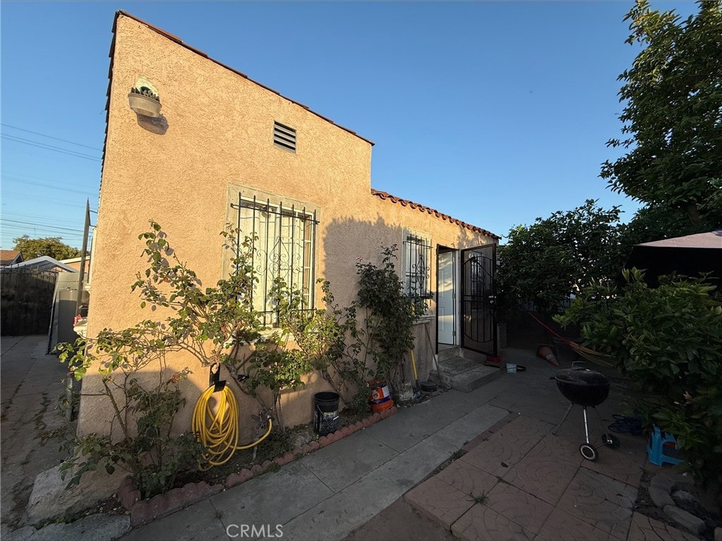 9418 Zamora Ave, Los Angeles, CA 90002 - view of side of property featuring stucco siding and a patio area