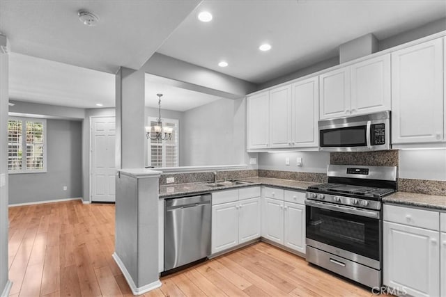 26327 Iris Ave Unit C, Moreno Valley, CA 92555 - kitchen with stainless steel appliances, recessed lighting, white cabinets, light wood finished floors, and a peninsula