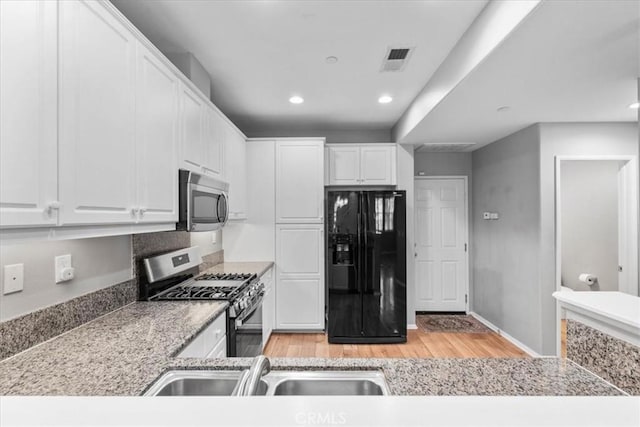 26327 Iris Ave Unit C, Moreno Valley, CA 92555 - kitchen featuring appliances with stainless steel finishes, light wood finished floors, white cabinetry, and recessed lighting