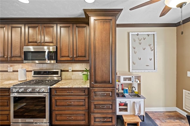 3197 Bexfield Ct, Riverside, CA 92503 - kitchen with stainless steel appliances, decorative backsplash, a ceiling fan, wood finished floors, and light stone counters