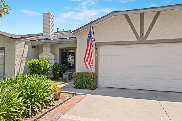 3197 Bexfield Ct, Riverside, CA 92503 - doorway to property with a chimney, stucco siding, a garage, driveway, and a shingled roof