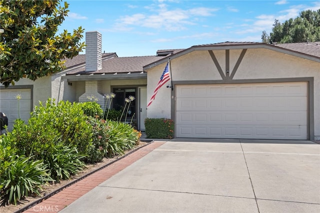 3197 Bexfield Ct, Riverside, CA 92503 - view of front of home featuring driveway, an attached garage, stucco siding, roof with shingles, and a chimney