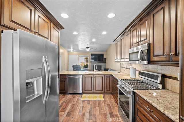 3197 Bexfield Ct, Riverside, CA 92503 - kitchen with stainless steel appliances, recessed lighting, light wood-type flooring, decorative backsplash, and light stone countertops