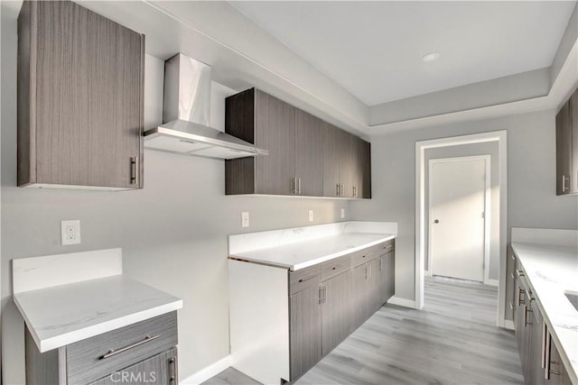 1438 W 69th St, Los Angeles, CA 90047 - kitchen featuring wall chimney range hood, light wood-style flooring, and gray cabinetry