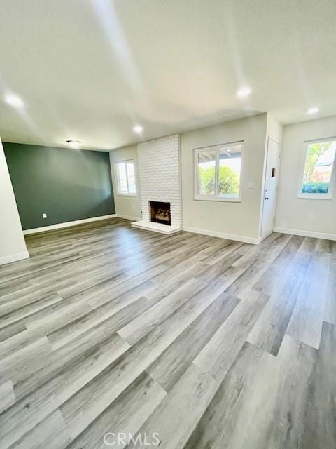 28838 Snead Dr, Menifee, CA 92586 - unfurnished living room with plenty of natural light, a fireplace, and wood finished floors