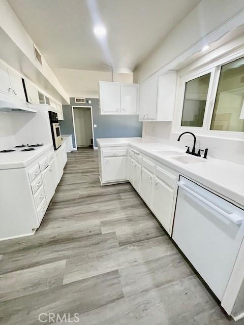28838 Snead Dr, Menifee, CA 92586 - kitchen featuring white dishwasher, white cabinets, light countertops, light wood-type flooring, and oven