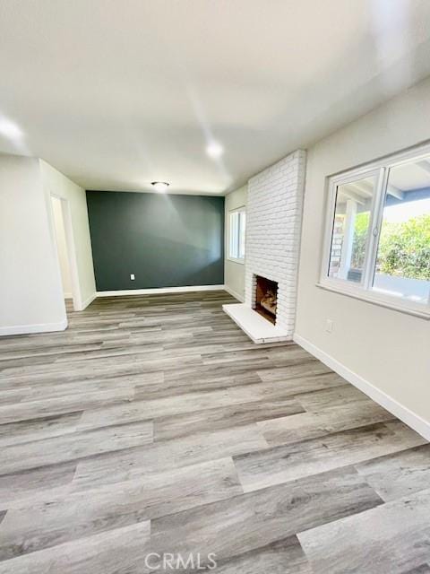 28838 Snead Dr, Menifee, CA 92586 - unfurnished living room featuring wood finished floors, a fireplace, and plenty of natural light