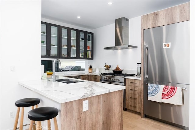 6191/2 Marguerite, Corona Del Mar, CA 92625 - kitchen with high quality appliances, wall chimney exhaust hood, a breakfast bar, a peninsula, and light stone countertops
