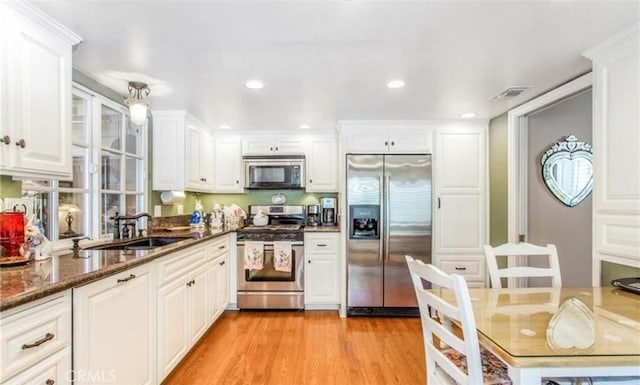856 Ardmore Cir, Redlands, CA 92374 - kitchen featuring appliances with stainless steel finishes, white cabinets, light wood finished floors, dark stone countertops, and recessed lighting