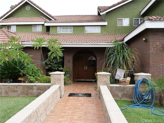 13761 Lomitas Ave, La Puente, CA 91746 - property entrance featuring a tile roof, stucco siding, and brick siding