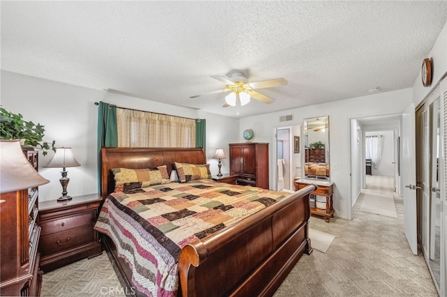 621 Shasta Way, Hemet, CA 92543 - bedroom featuring light carpet, a textured ceiling, a closet, ceiling fan, and ensuite bath