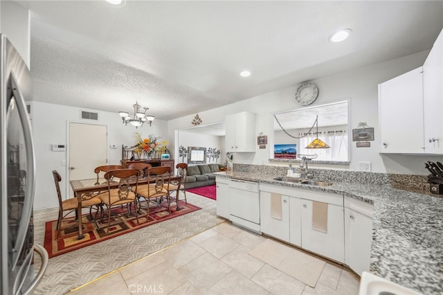 621 Shasta Way, Hemet, CA 92543 - kitchen with white dishwasher, stainless steel refrigerator, a chandelier, white cabinets, and decorative light fixtures