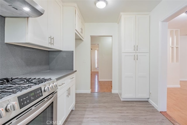 16908 Los Alimos St, Granada Hills, CA 91344 - kitchen with exhaust hood, stainless steel gas stove, light wood-style flooring, and white cabinets
