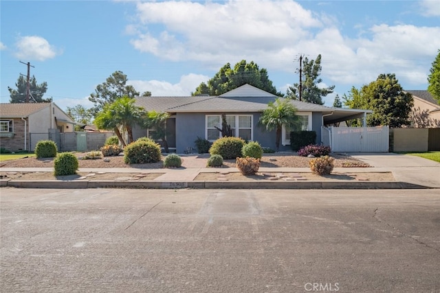 16908 Los Alimos St, Granada Hills, CA 91344 - ranch-style house with driveway, an attached carport, stucco siding, and a gate
