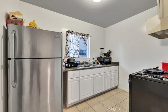 16908 Los Alimos St, Granada Hills, CA 91344 - kitchen featuring freestanding refrigerator, gas stove, dark countertops, light tile patterned floors, and white cabinets