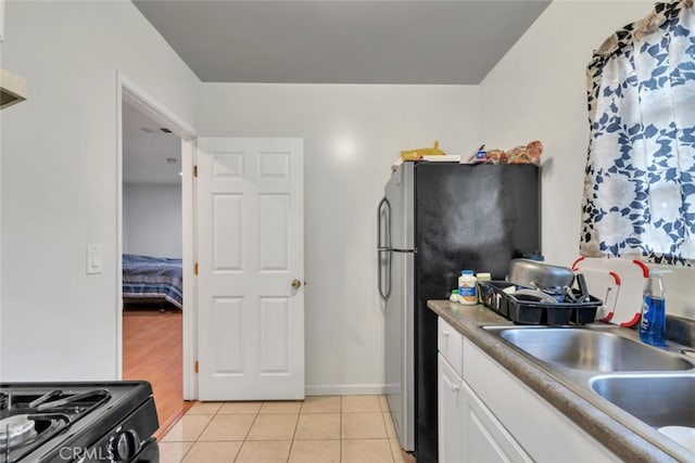 16908 Los Alimos St, Granada Hills, CA 91344 - kitchen with white cabinets, freestanding refrigerator, range with gas stovetop, and light tile patterned floors